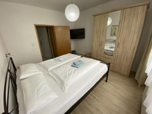 a large white bed in a bedroom with a mirror at Holiday apartment on the Anger in Wernigerode