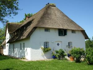 OsterheverにあるPoppenbüll thatched houseの茅葺き屋根の古い白い家