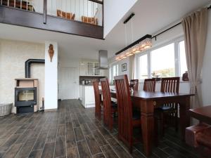 a kitchen and dining room with a wooden table and chairs at To"n Lüchtfüer Comfortable holiday residence in Dwarsdorf