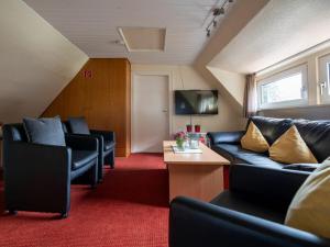 a living room with couches and a tv at Panorama Modern retreat in Eslohe