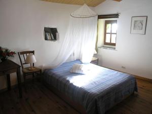 a bedroom with a bed and a window and a chair at Holiday home Mirabel Sous les roches in Mirabel