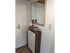 a bathroom with a sink and a mirror and a counter at Huus Meta Modern retreat in Krummhörn +26 photos
