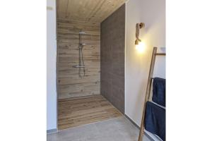 a shower in a bathroom with a wooden wall at Holiday home Chalet 48 in Mayen +12 photos