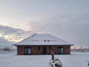 a small brick house with snow on the roof at Holiday home Stieglund in Jörl