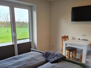 a bedroom with a bed and a desk and a window at Holiday home Stieglund in Jörl