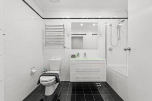 a white bathroom with a toilet and a shower at Comforting 2BR House & FishMarket & Casino-3 mins walk in Sydney +15 photos