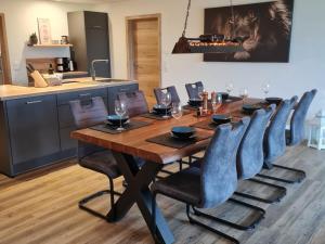 a dining room table with chairs and a kitchen at Holiday home Stieglund in Jörl