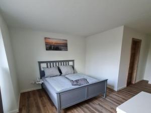 a bedroom with a bed in a white room at Holiday home Stieglund in Jörl