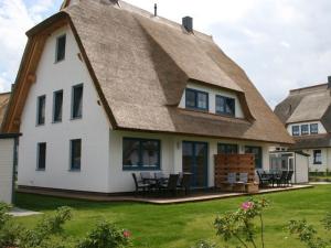 a thatched roof house with a patio at Ostseebrandung - Haus Seepferdchen in Dranske