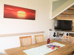 a dining room with a table and a television at Ostseebrandung - Haus Seepferdchen in Dranske +16 photos