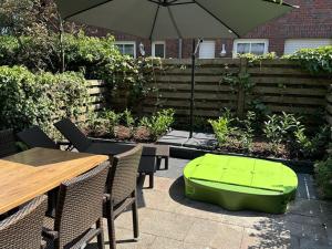un pouf vert posé sur une terrasse avec des tables et un parasol dans l'établissement Raceweide - MarBi Alles inbegrepen, à Dangast