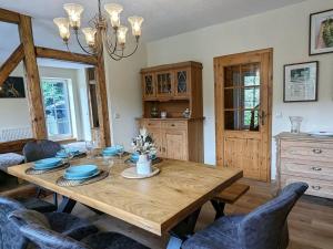 a dining room with a wooden table and chairs at Old Forge Modern Retreat in Scharfenstein