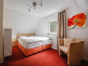 a bedroom with a bed and a chair and a window at Panorama Modern retreat in Eslohe