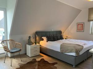 una camera da letto con un letto grande e una sedia di Haus Seeblick Modern retreat a Göhren-Lebbin