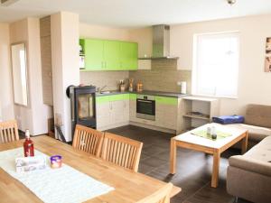a kitchen and living room with a table and a couch at Ostseebrandung - Haus Seepferdchen in Dranske