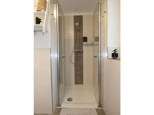 a shower with a glass door in a bathroom at Marinapark 147 Modern retreat in Walchum +26 photos
