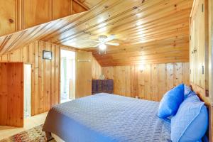 a bedroom with wooden walls and a bed with blue pillows at Cleveland Heights Home with Sunroom Park Across St! in Cleveland Heights