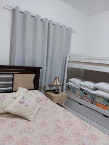 a bedroom with two bunk beds and a lamp at Porto Belo Perequê in Porto Belo