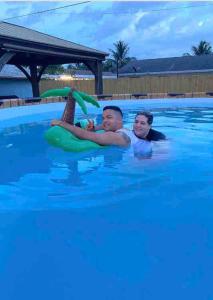 ウェストパームビーチにあるLittle Paradise In Palm Beachのスイミングプールの男女