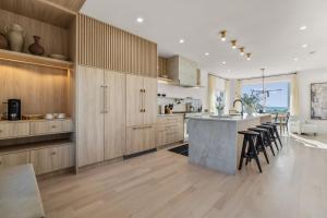 a kitchen with wooden cabinets and a island with bar stools at Pocasset Family retreat ocean view in Bourne