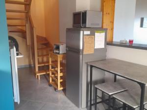 a kitchen with a refrigerator with a microwave on top of it at Gîte familial à Cornimont avec Wifi et parking - FR-1-589-84 in Cornimont
