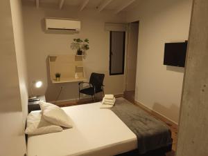 a bedroom with a bed and a desk and a chair at La Carpita Hotel in El Poblado