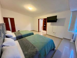 a room with two beds and a flat screen tv at 20# Habitación doble cama in Miravalle