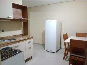 卡诺阿斯Pousada Maranata Canoas的厨房配有白色冰箱和桌子