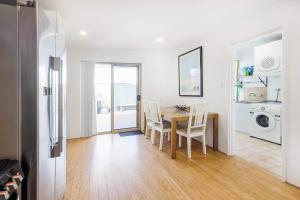 パースにあるSunset Villa Scarboroughのテーブルと椅子のあるキッチンとダイニングルーム +26枚の写真
