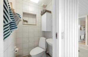 a white bathroom with a toilet and a sink at Nordenhus in Nyborg +8 photos