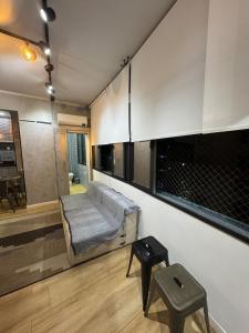 a room with a bed and a stool in it at Kitnet 1109 in São Vicente