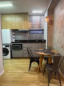 a kitchen with a table and chairs in a room at Kitnet 1109 in São Vicente