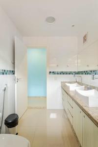 a white bathroom with two sinks and a shower at Mansão Santa Tereza delux in Rio de Janeiro