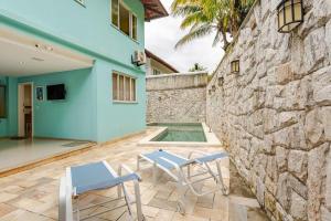 a patio with two chairs and a stone wall at Mansão Santa Tereza delux in Rio de Janeiro