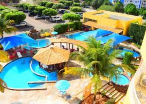 an overhead view of a swimming pool with blue umbrellas at Condomínio Residencial Thermas Place Apto 119 in Caldas Novas +9 photos