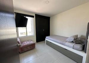 a small bedroom with a bed and a window at Departamento De Lujo Fracc Element in San Agustín