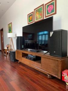 ein Wohnzimmer mit einem Fernseher auf einem hölzernen Entertainment-Center in der Unterkunft Rose Villa Thai Nguyen - Venuestay in Thượng Nhân