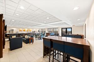 a bar in a waiting room with chairs and tables at Comfort Inn & Suites Decatur-Forsyth in Forsyth