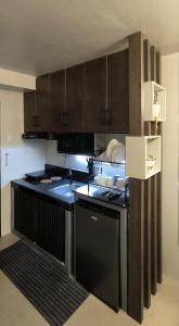 cocina con armarios marrones y horno con fogones en Bee Homestay Urban Deca Homes Tipolo, Mandaue City Cebu, en Mandaue