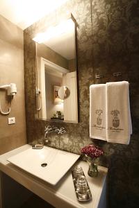 a bathroom with a sink and a mirror and towels at Hotel Palacio Muñatones in Muskiz