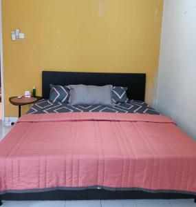 a bed with a pink comforter in a room at Nazone Homestay Kajang Perdana in Kajang
