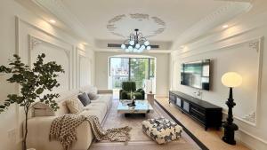 a living room with a couch and a tv at Eastern Hub - Bund Branch Quality Renovated Luxury 3Bedroom, Spacious Living Room Fully Equipped Haiyue Garden in Shanghai