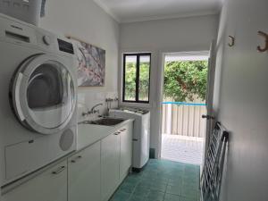 a kitchen with a sink and a washing machine at Sea Breeze in Elizabeth Beach