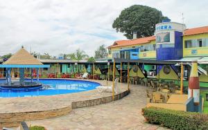 um resort com piscina, mesas e cadeiras em Hotel Riviera D Amazonia Belem Ananindeua em Belém