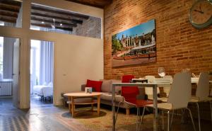 a living room with a brick wall and a table and chairs at Happy People Plaza España Apartments in Barcelona +46 photos