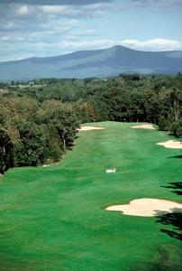 an aerial view of a golf course with mountains in the background at Luray Caverns Motels in Luray