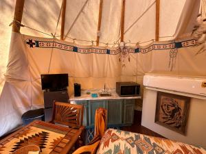 a room with a tent with a table and a microwave at Bandera Stronghold Retreat in Bandera