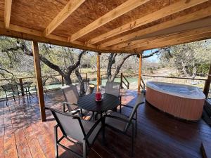 a patio with a table and chairs and a hot tub at Bandera Stronghold Retreat in Bandera