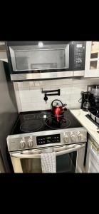 a kitchen with a stove with a tea kettle on it at Furnished apartmt near down town with king bed in Dallas +5 photos