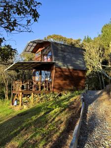 een houten huis met een dak op een heuvel bij Peregrino Glamping 1 in Medellín